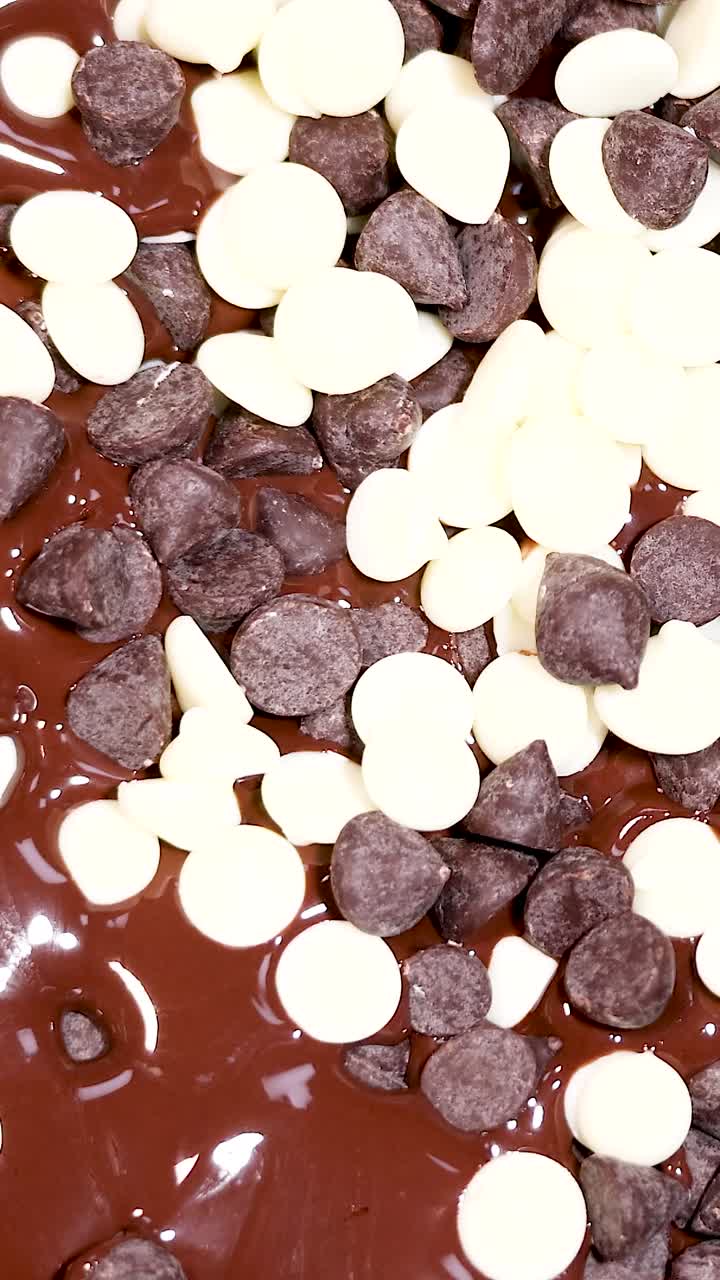 Gocce di cioccolato bianco e fondente che si mescolano