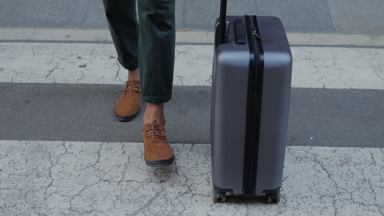 Man Walking with Suitcase Across Crosswalk