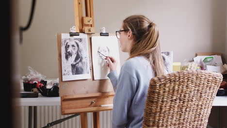 view through door of female teenage artist at easel drawing picture of dog in charcoal