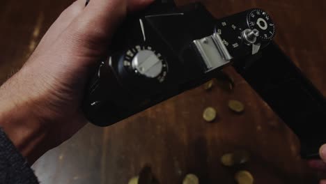 Opened-camera-back-displays-money-coins-it-has-made-and-are-poured-onto-floor