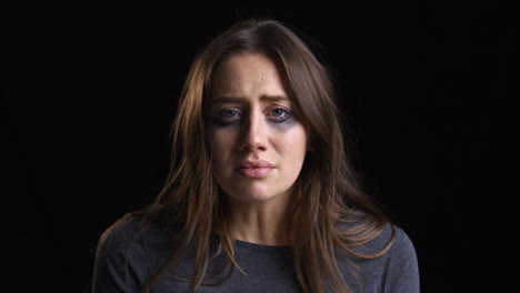 studio portrait shot of crying woman with smudged make up