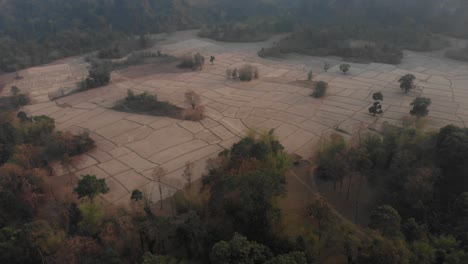 Weitwinkelaufnahme-Der-Landschaft-Von-Laos-Mit-Trockenen-Feldfrüchten-Bei-Sonnenuntergang,-Luftaufnahme