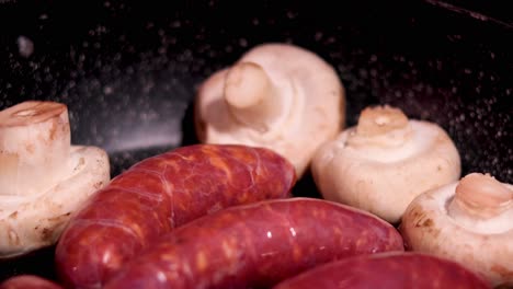 sausages and mushrooms frying in a pan