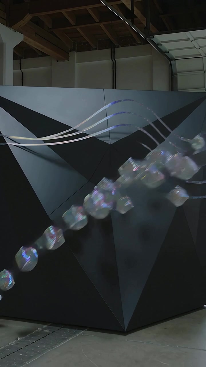 Video verticale: Nastri che si sollevano, cubi che entrano da destra, illuminazione triangolare in una baia di magazzino