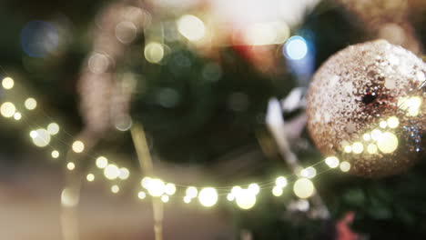 animation of string lights and blurred christmas tree decorations