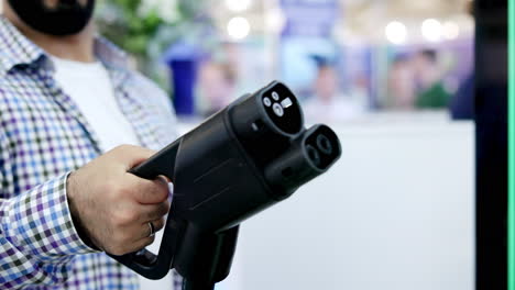 person holding an electric vehicle charging connector