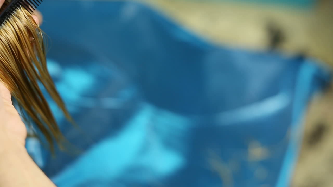 Stylist dying hair. Professional hairdresser dyeing hair of her client at beaty salon