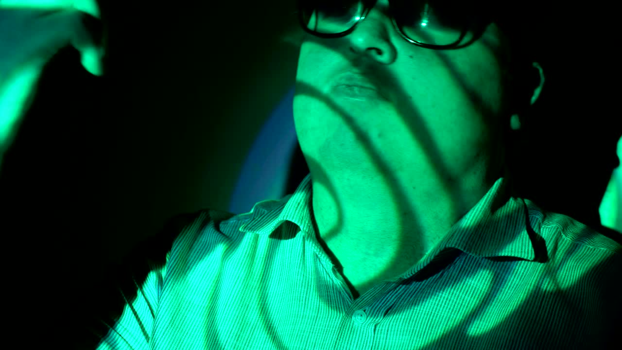 retrato de un hombre gordo en un haz de luz multicolor.