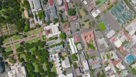 Birds-eye-ascending-footage-of-buildings-and-parks-in-city.-Greenery-in-town,-trees-and-lawns.-Cape-Town,-South-Africa