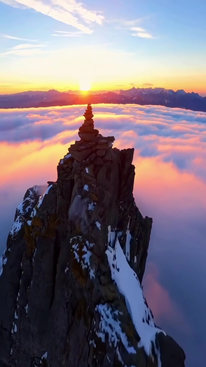 Maestosa vetta della montagna sopra le nuvole all'alba