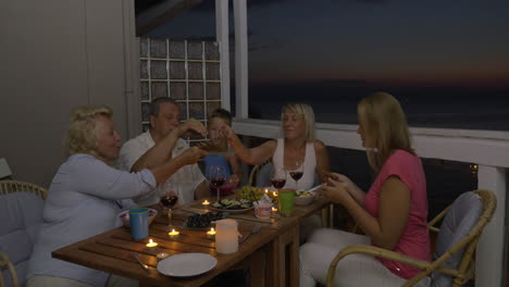 family having meal on balcony in the evening