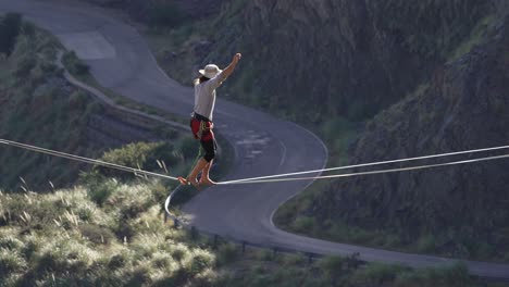 a young man taking a fall on a highline over a road in slow motion