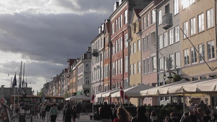 Ripresa con movimento tilt down di persone che camminano nel porto di Nyhavn a Copenaghen