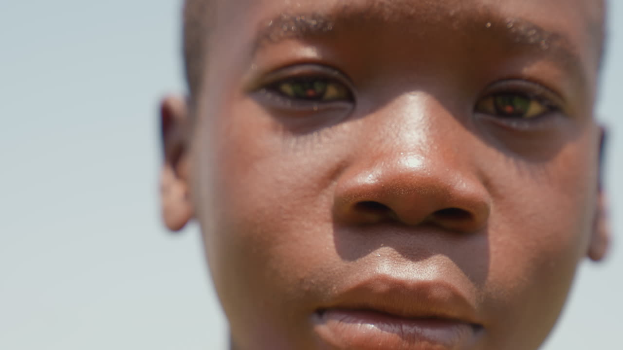 Black boy intense closeup sweating skin and focused eyes, detailed texture and sunlight reveal grit and emotion, intimate portrait of determination, raw honesty and athletic resolve
