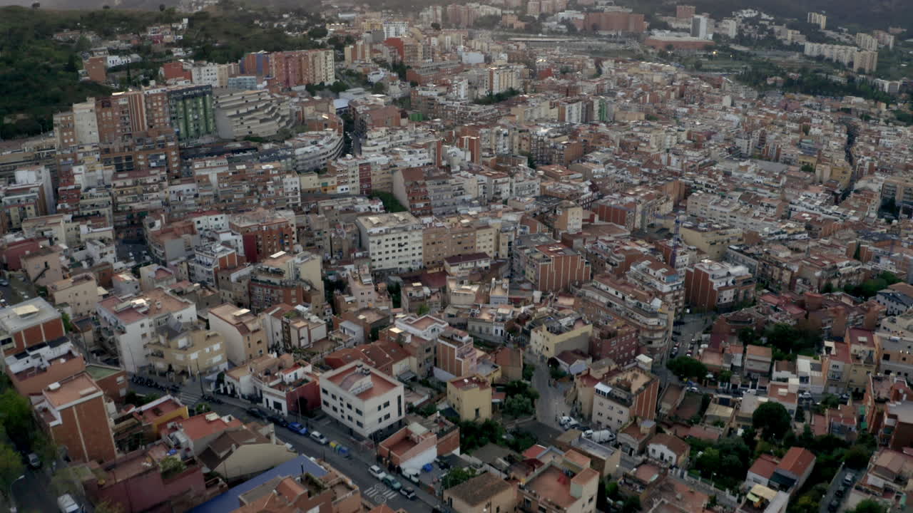 Vista aérea de cima para baixo de um bairro no vale de Barcelona, inclinando para cima para revelar o horizonte da colina do Bunker De Carmel