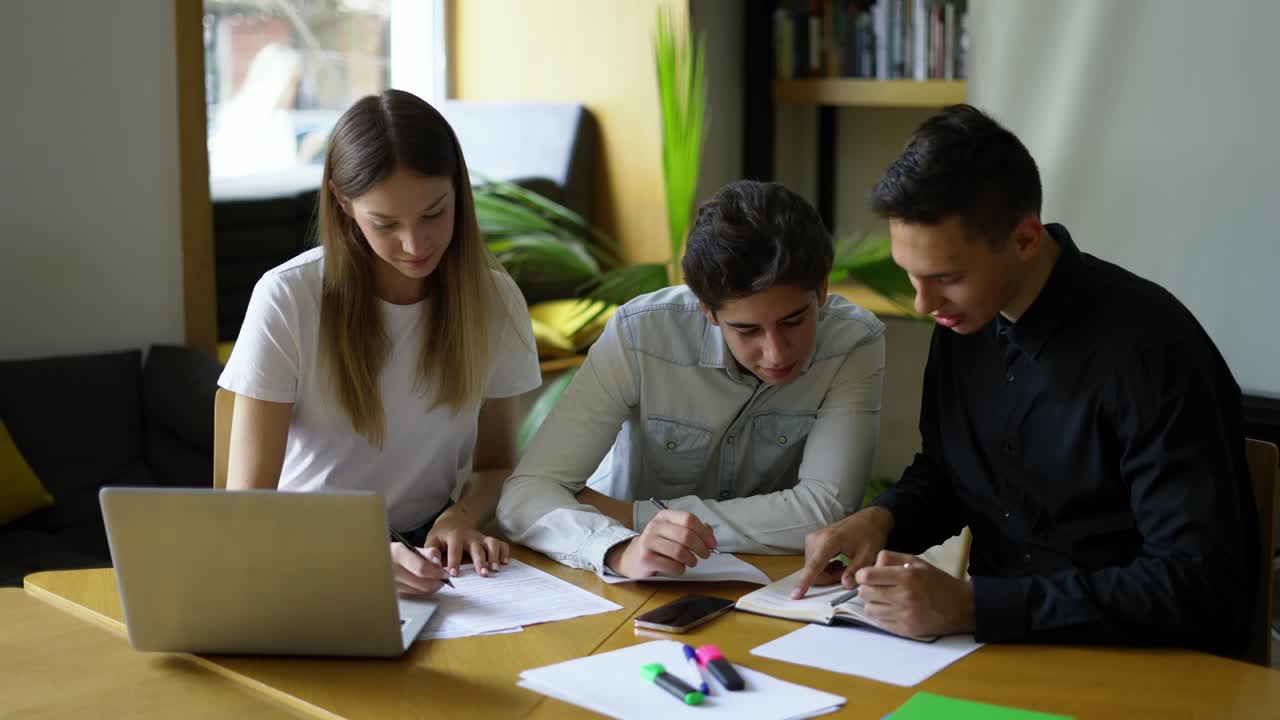 y un hombre adulto en una camisa se sienta en una mesa, las manos están ubicadas en un cuaderno