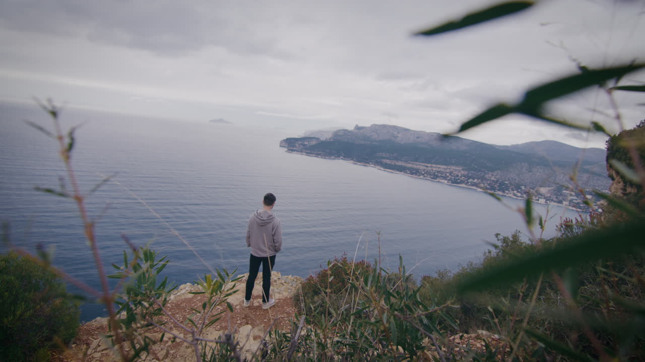 절벽 가장자리에서 푸른 지중해를 혼자 상하는 남자