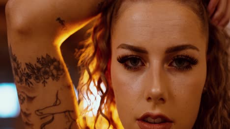 tattooed woman with fire explosion in dramatic cinematic scene, close up