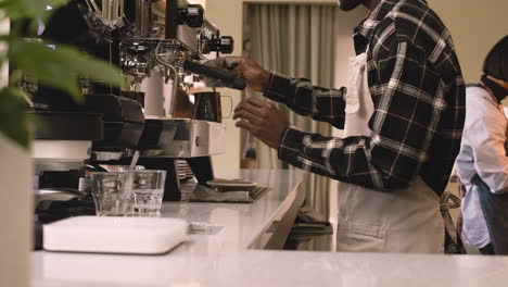 two multiethnic waiters working in a coffee shop 1