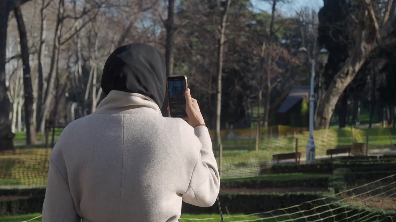 Vrouw in het park neemt video op met smartphone