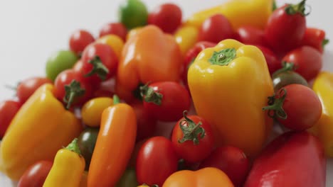 Video-of-fresh-peppers-and-tomatoes-spinning-on-white-background