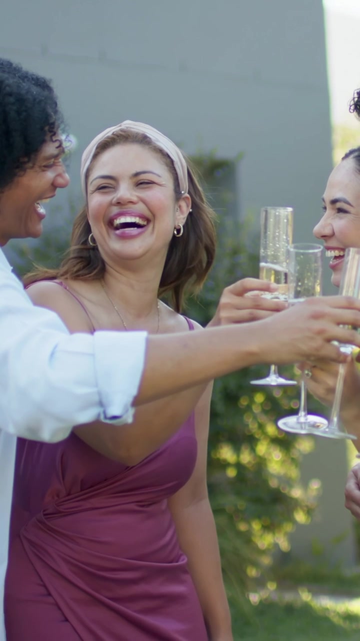 Vertical video: Raising glasses mauve dress woman leading group clinking flutes in garden, toasting