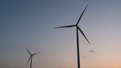 wind turbines silhouette against the blue-sky during sunset, clean alternative energy in thailand and mainland southeast asia