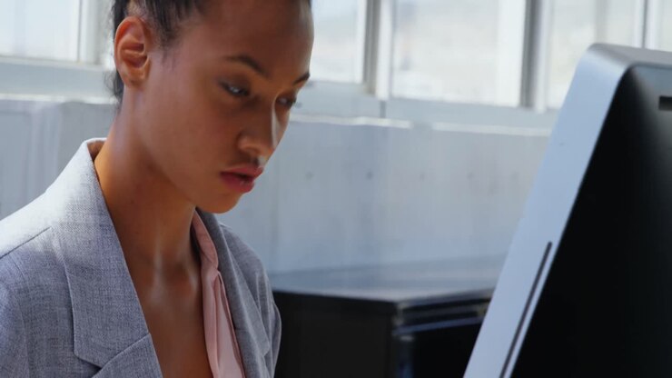 Vista laterale di una donna d'affari afroamericana che lavora al computer alla scrivania in un ufficio moderno 4k