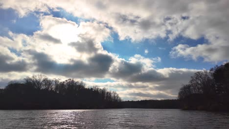 A serene slow-mo of vast sky and distant woods, filmed from a camo duck boat on the water.