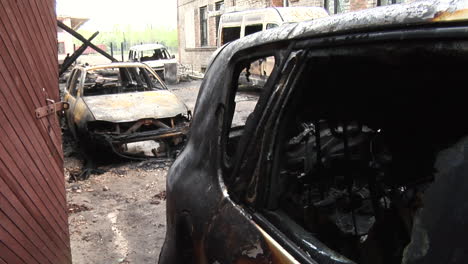 restos de una casa quemada y un coche destruido por un incendio en una casa