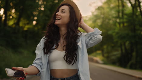 mujer sonriente con un teléfono inteligente en el parque. chica linda dando la vuelta al aire libre