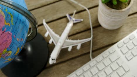 Keyboard,-airplane-model-and-globe-on-table-4k