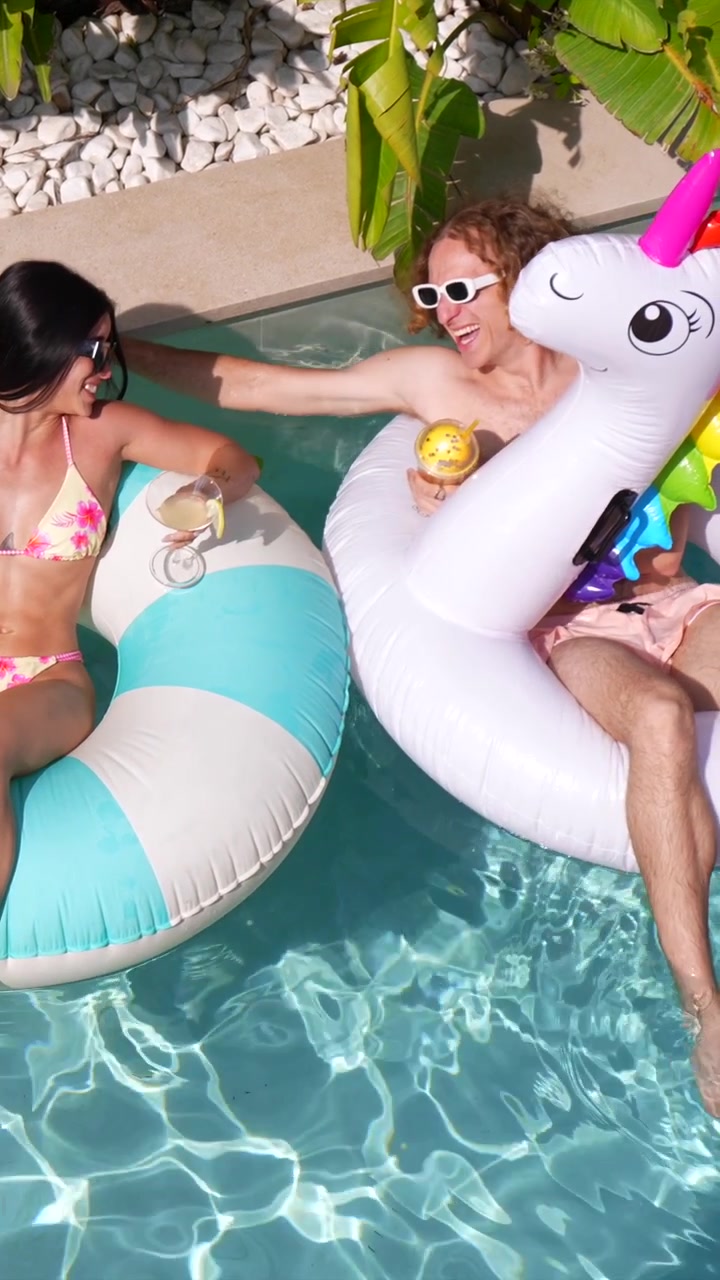 Happy Couple Relaxing on Inflatable Floats in Swimming Pool