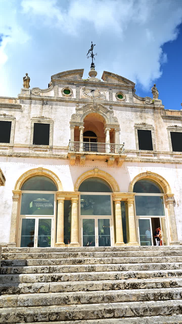 Facciata della casa principale storica del Vizcaya Museum and Gardens. Vista dettagliata della facciata in pietra ornata, degli archi e delle statue del Vizcaya Museum a Miami sotto un cielo nuvoloso.