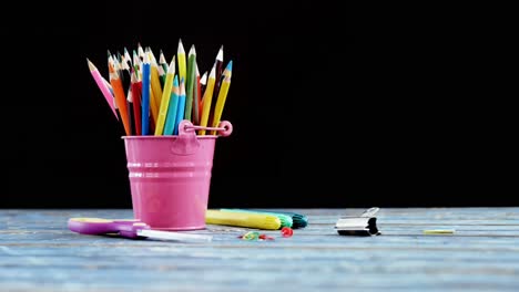 Iconos-Conceptuales-De-Química-Y-Ciencia-Contra-Un-Cubo-Lleno-De-Lápices-De-Colores-Sobre-Una-Mesa-De-Madera