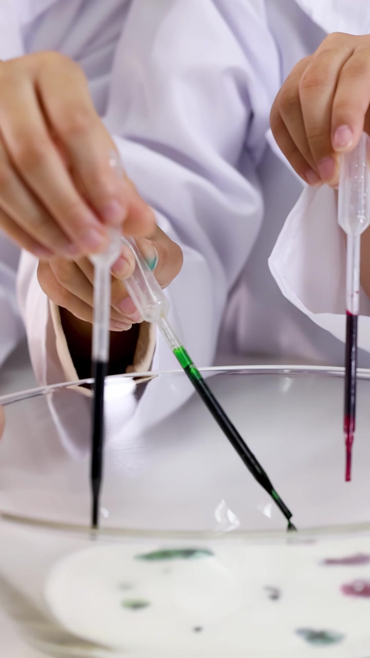 Scientist Using Droppers to Add Food Coloring to Milk in Laboratory