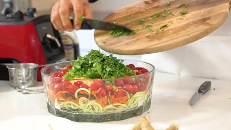 Adding cilantro to bowl zucchini noodles zoodles adding to bowl healthy vegan vegetarian lifestyle diet detox