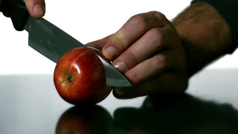 man slicing apple with large knife