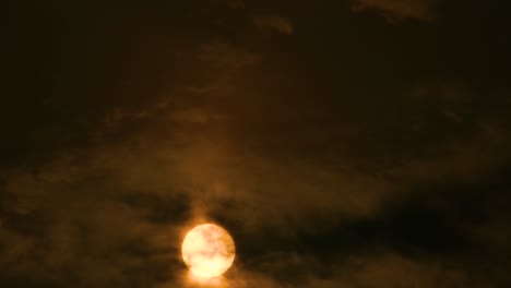 Golden-sun-shining-as-dark-clouds-moving-over-dark-sky