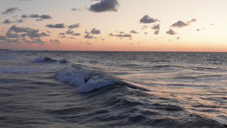 surfers in front of the touristic town domburg in the netherlands during sunset