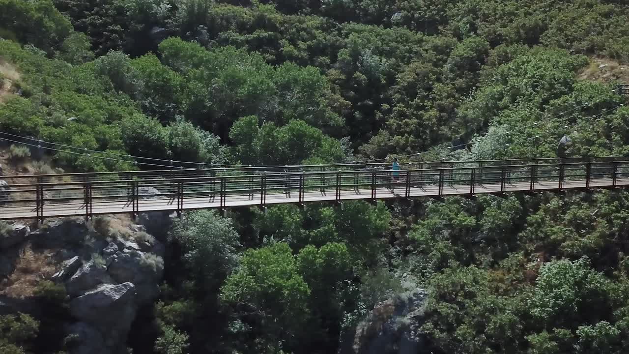 disparo de un dron siguiendo a un hombre activo corriendo en un puente colgante colgante al aire libre sobre el cañón del oso en draper city, utah