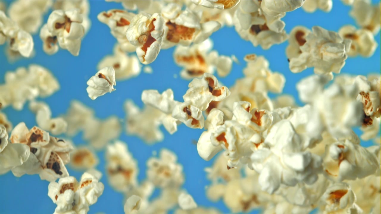 Popcorn che cade al rallentatore su sfondo blu