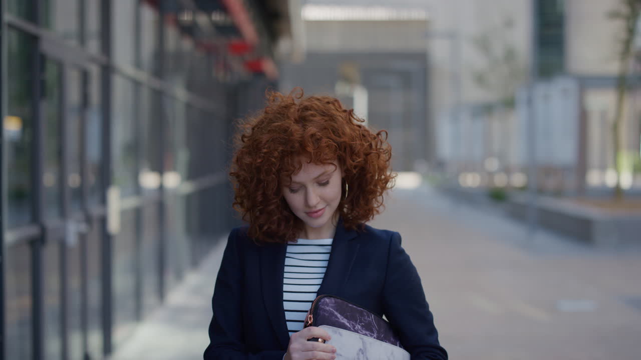 ritratto giovane donna d'affari elegante sorridente carina di testa rossa che gode di uno stile di vita urbano professionale in città sicura di sé donna di successo dirigente in rallentatore