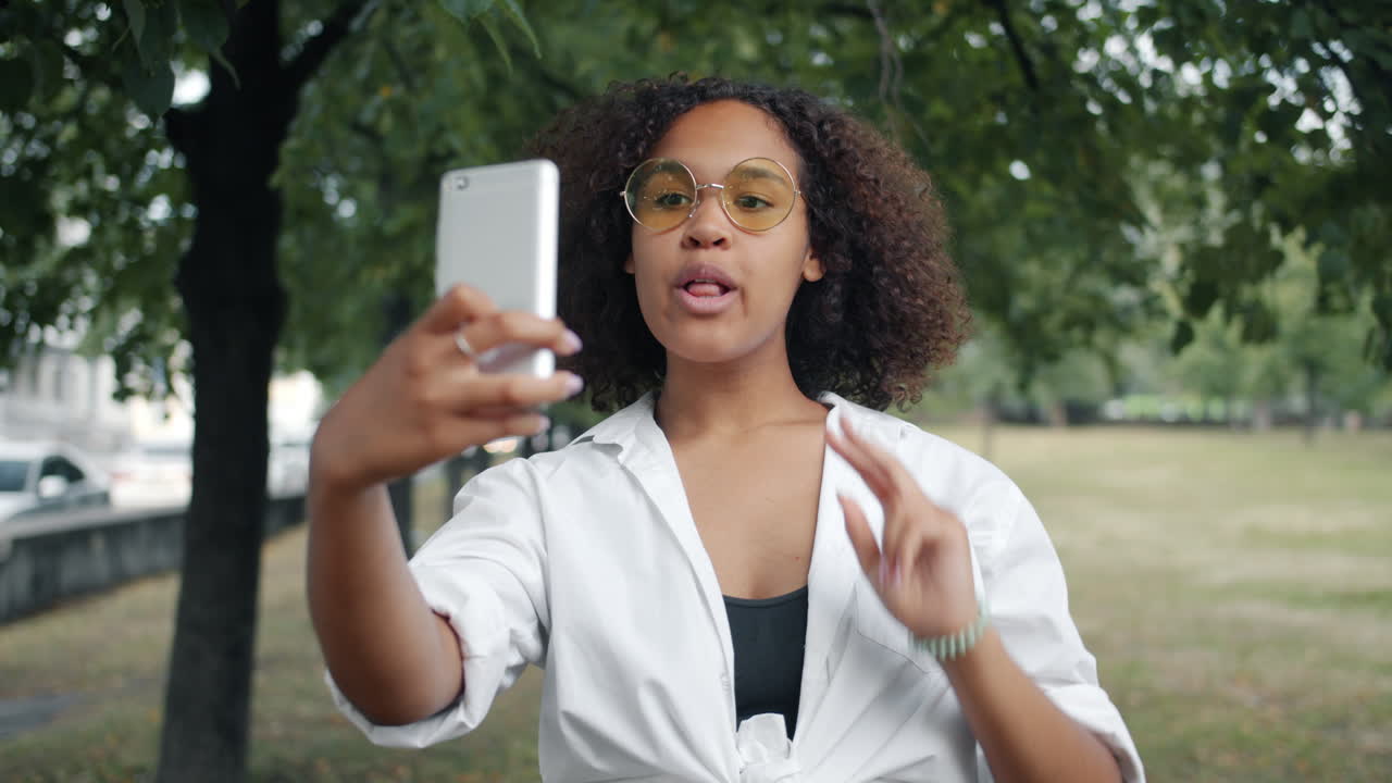 una mujer joven tomando una selfie en un parque.