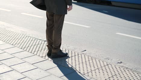 visually impaired man crossing the road with his stick with the help of tactile pedestrian sidewalk for the visually impaired in the city.