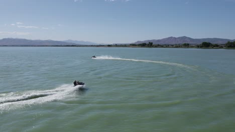 pair of two people having fun riding jet ski sea doos on utah lake, aerial