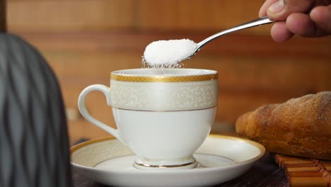 slow motion of pouring white sugar in a coffee cup , top view ,