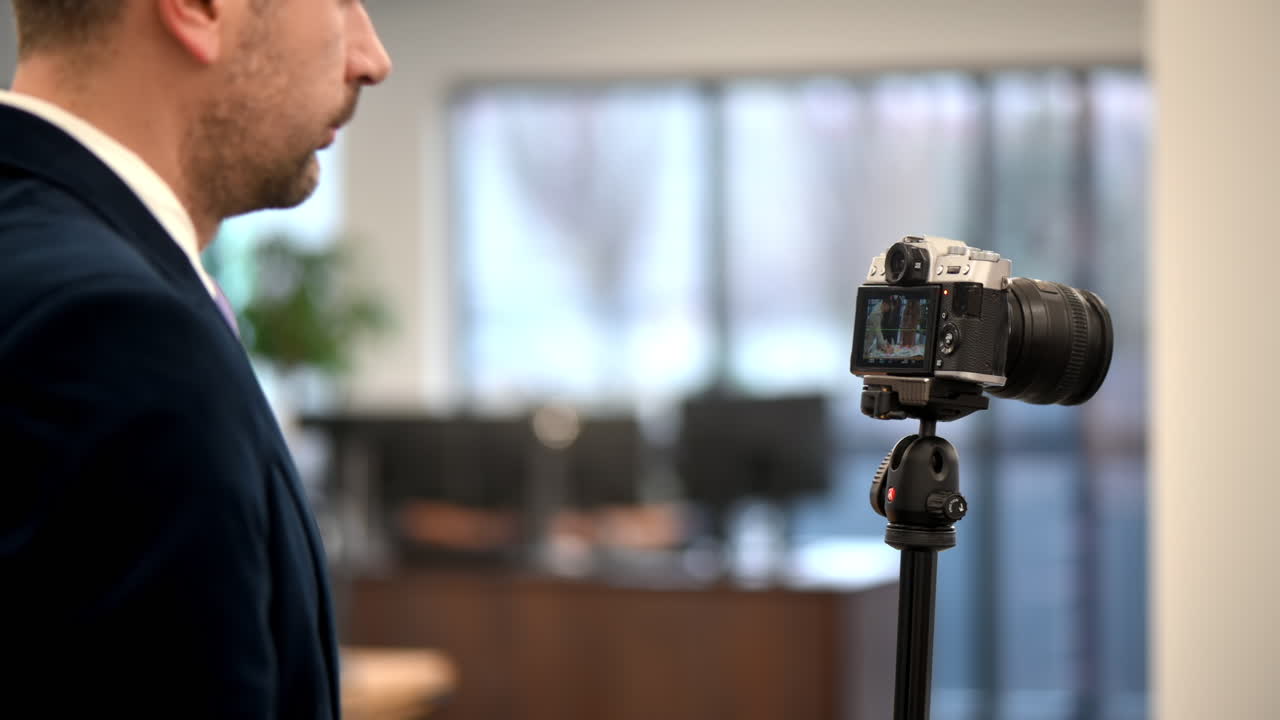 Professioneller Fotograf, der in einem Büro mit einer Kamera auf einem Stativ fotografiert