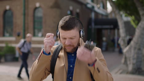 retrato de un encantador hombre caucásico con auriculares escuchando música usando un teléfono inteligente en la ciudad