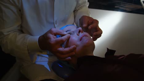 Optometrist-examining-patient-eyes-in-clinic-4k